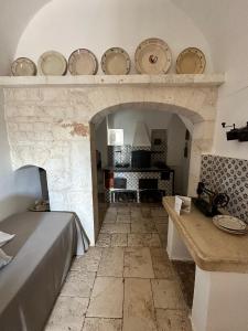 孔韦尔萨诺Masseria Montepaolo Dimora di Charme的一间设有石制壁炉的客房,架子上摆放着盘子