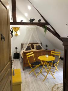 MontpollinUn coin de paradis的一间卧室配有一张床和一张黄色的桌子及椅子