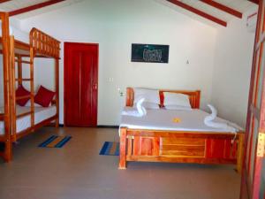 基林德Kirinda Heaven - Yala的一间卧室设有两张双层床和一扇红色的门。