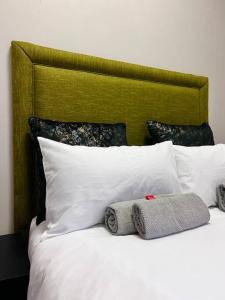 约翰内斯堡Matcha themed Apartment in City的一张带白色枕头和绿色床头板的床