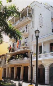 卡塔赫纳Bello apartamento corazón de Cartagena colonial的带阳台和街灯的大型白色建筑