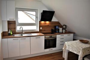 海德堡Heiligenbergblick的厨房配有白色橱柜、水槽和窗户。