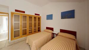 圣米格尔德阿沃纳Villa La Orotava的一间设有两张床和橱柜的房间