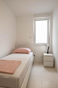 波弗加纳Apartment Dubravka的白色的卧室设有床和窗户
