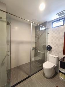 Tràm ChimWildbird Hotel的一间带卫生间和玻璃淋浴间的浴室