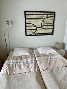 JoutsaLamminmäen Juhla ja Peti的卧室配有两张床,墙上挂着一幅画