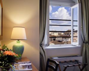 佛罗伦萨波提瑟利酒店的一张带台灯的桌子和一个美景窗户