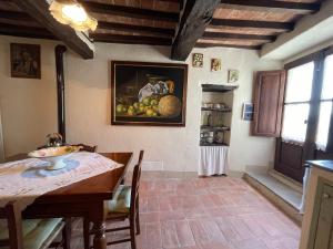 科尔托纳Borgo Chiantina的厨房配有桌子,墙上挂有水果画