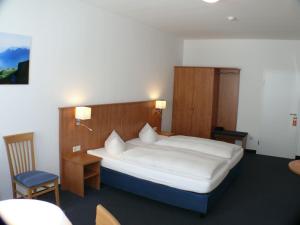 科堡加尼酒店 - 格码大宅的一间卧室配有一张大床和一把椅子