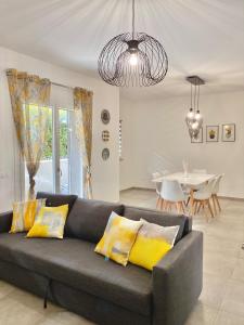 马里诺Cava Home - Castelli Apartments的客厅配有带黄色枕头的灰色沙发