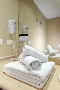 拉马约Camberland Resort & Spa Ramallo的浴室提供白色毛巾和镜子