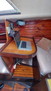 巴塞罗那Boat Barcelona Yacht的一张桌子,上面有笔记本电脑,旁边是一张床