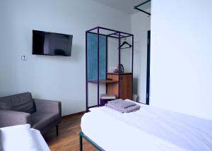 慕尼黑Das Schreder Hotel的一间卧室配有一张床、一把椅子和镜子