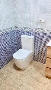 萨洛RoNi RoOms的浴室设有蓝色瓷砖墙壁,配有白色卫生间