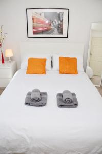 斯坦维尔33SM Dreams Unlimited Serviced Accommodation- Staines - Heathrow的卧室配有白色床和毛巾