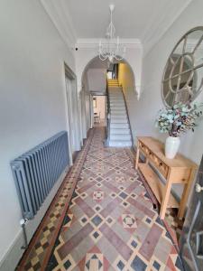 亨斯坦顿Victorian Beach Villa, Hunstanton Norfolk的走廊上设有楼梯和鲜花桌