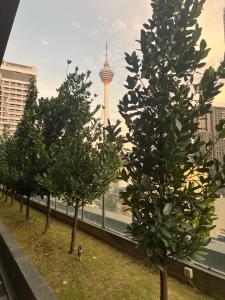 吉隆坡Anggun KL Malaysia的一座有电视塔的建筑顶部的一排树木