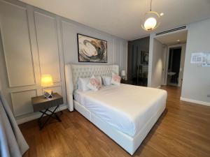 吉隆坡Anggun KL Malaysia的卧室配有白色床和粉红色枕头