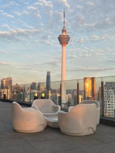 吉隆坡Anggun KL Malaysia的屋顶设有椅子,享有太空针的景致
