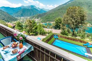 皮耶韦迪莱德罗Le Terrazze sul Lago - Ledro House的阳台享有房屋的景致,配有带食物的桌子和游泳池
