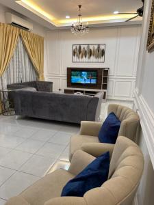麻坡The Amore Homestay的客厅配有两张沙发和一台电视