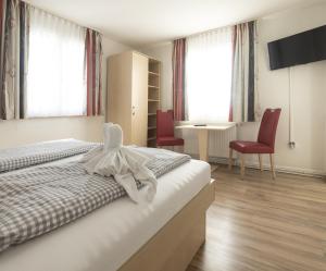 博德曼路德维希港Gasthaus Traube, Ludwigshafen, Bodensee, Seenah gelegen的酒店客房,配有一张床和两张红色椅子