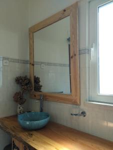 新普罗恩萨Casa Xara的浴室设有蓝色的碗水槽和镜子