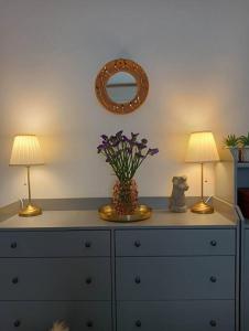卡利亚里Dom Apartment Luxury的梳妆台,上面有两盏灯和一个花瓶