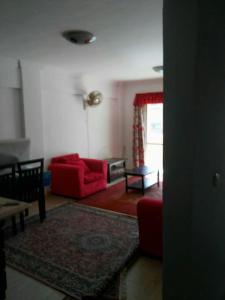 艾因苏赫纳شاليه بقرية كورنادو السخنه的客厅配有红色的沙发和桌子