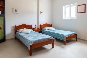 凯法洛斯Ficus Traditional Apartments的两张床位于带窗户的房间内