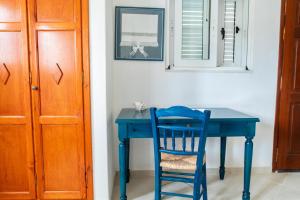 凯法洛斯Ficus Traditional Apartments的蓝色桌子、蓝色椅子和镜子
