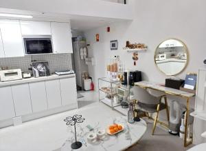 大邱Angel House的白色的厨房配有桌子和镜子