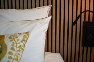 吉福蒙尚波贝尔Le Cheval Blanc - Lac du Der - Logis Hotel的床上有2个枕头
