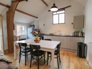 惠灵顿Brimley Barn的厨房以及带白色桌椅的用餐室。