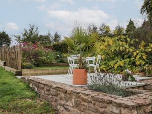 惠灵顿Brimley Barn的一个带两把椅子和盆栽的花园