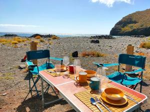 戈梅拉岛圣塞瓦斯蒂安Furgoneta Camper En La Gomera的海滩上的桌椅