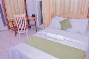 基加利INZOZI AFRICA HOUSE B&B- Kacyiru的一间卧室配有一张带椅子的床和一张书桌