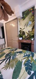 里昂Studio de charme au cœur de Lyon的一间卧室配有一张床铺,床上有毯子,上面有树叶