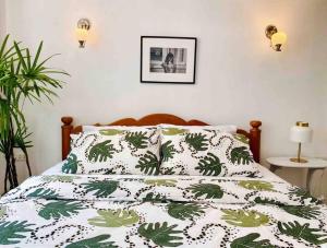 曼谷Flip Flop In Townhouse的一张带绿色和白色棉被的床