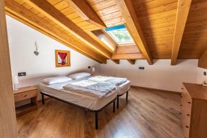 皮耶韦迪莱德罗Casa Panorama - Ledro House的一间卧室设有一张床和木制天花板