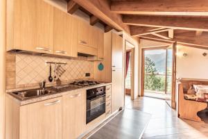 皮耶韦迪莱德罗Casa Panorama - Ledro House的厨房配有木制橱柜、水槽和炉灶。