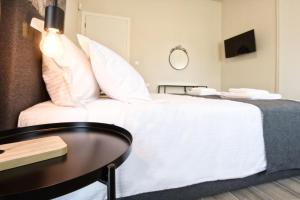 马科普隆Aellō luxury apartments的卧室配有白色的床和桌子