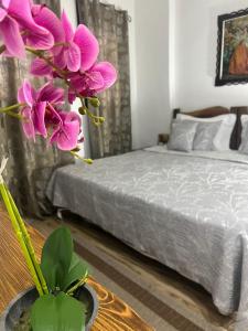 培拉特Hotel Omer的一间卧室配有一张床和一个紫色花瓶