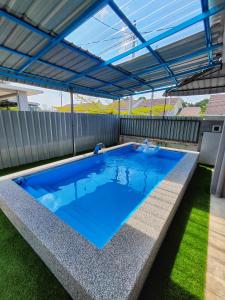 淡马鲁Homestay Temerloh Near Hospital with Private Pool Wi-Fi Netflix的一个带屋顶的后院游泳池