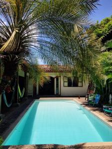 莱昂Casa Riverstone的一座棕榈树和房子的游泳池