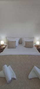 伊利扎Villa Bella的一张配有白色床单和枕头的大床
