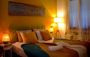 罗德镇Carmen Art Hotel的一间卧室配有一张黄色墙壁的床和两盏灯。