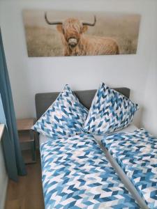 梅明根Ferienwohnung Luitpold 1的一张带两个枕头的沙发,一张牛的照片