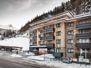 索尔登Valentin Design Apartments的一座位于雪覆盖的山边的建筑