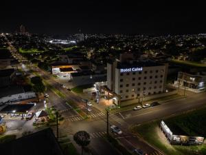 乌穆阿拉马Hotel Caiuá Lago Umuarama的城市的夜间景观,酒店俱乐部